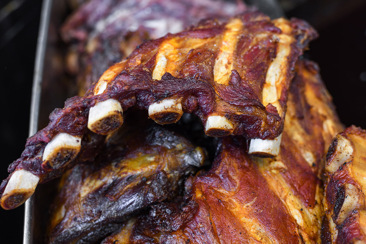 Marinated pork spare ribs, stack or pile of fresh grilled meat during barbeque, BBQ concept. Food Buffet Catering Dining Eating Party Sharing Concept